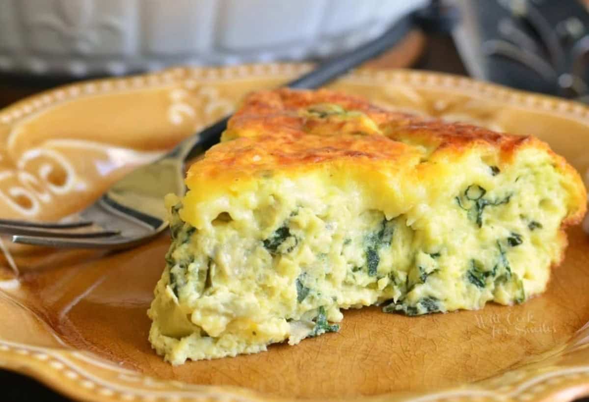 slice of spinach artichoke crustless quiche on a brown plate.