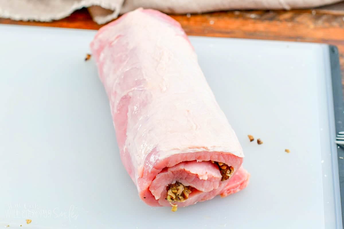 rolled and stuffed pork loin on a cutting board.