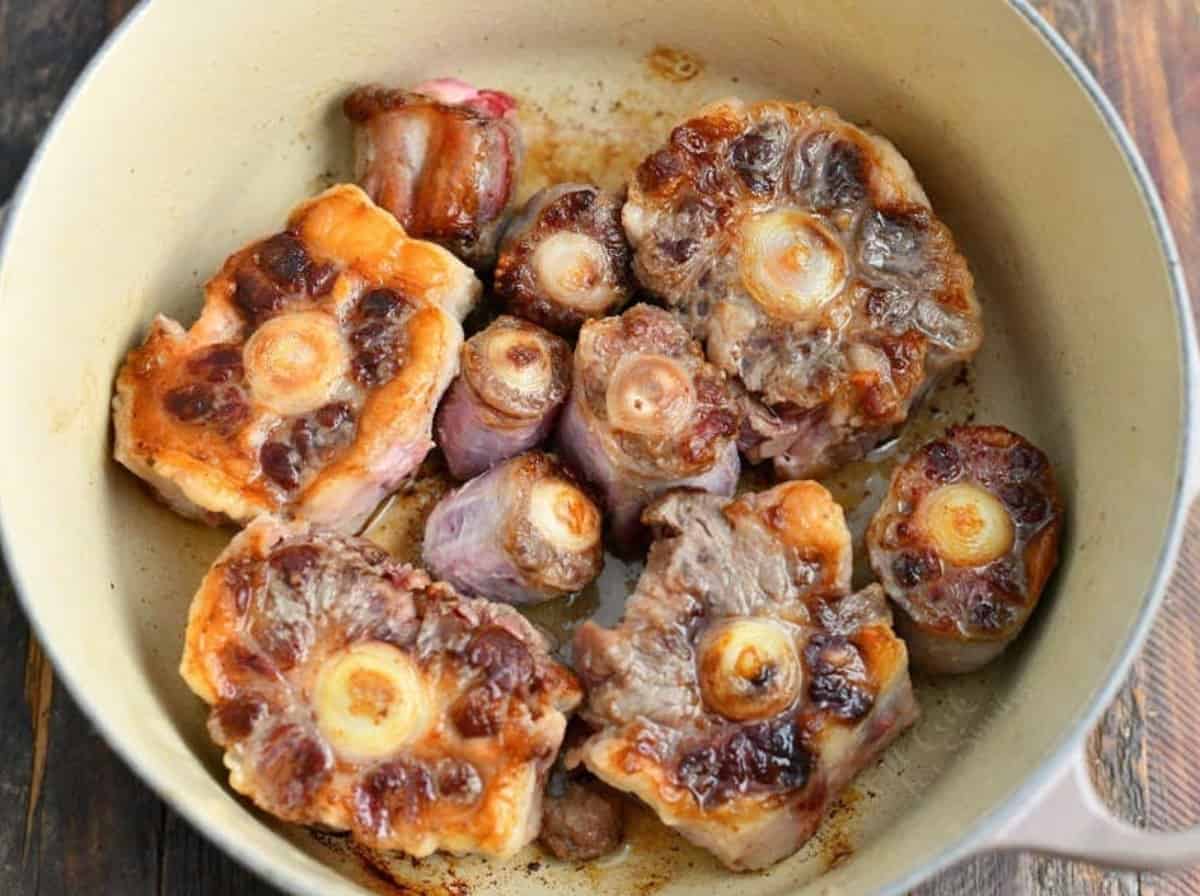 searing marrow bones in a Dutch oven pot.