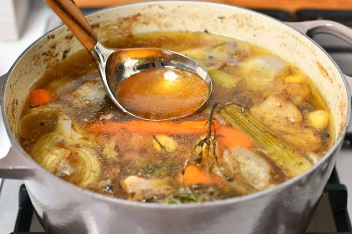 cooked beef stock with meat and veggies in the pot on the stove.