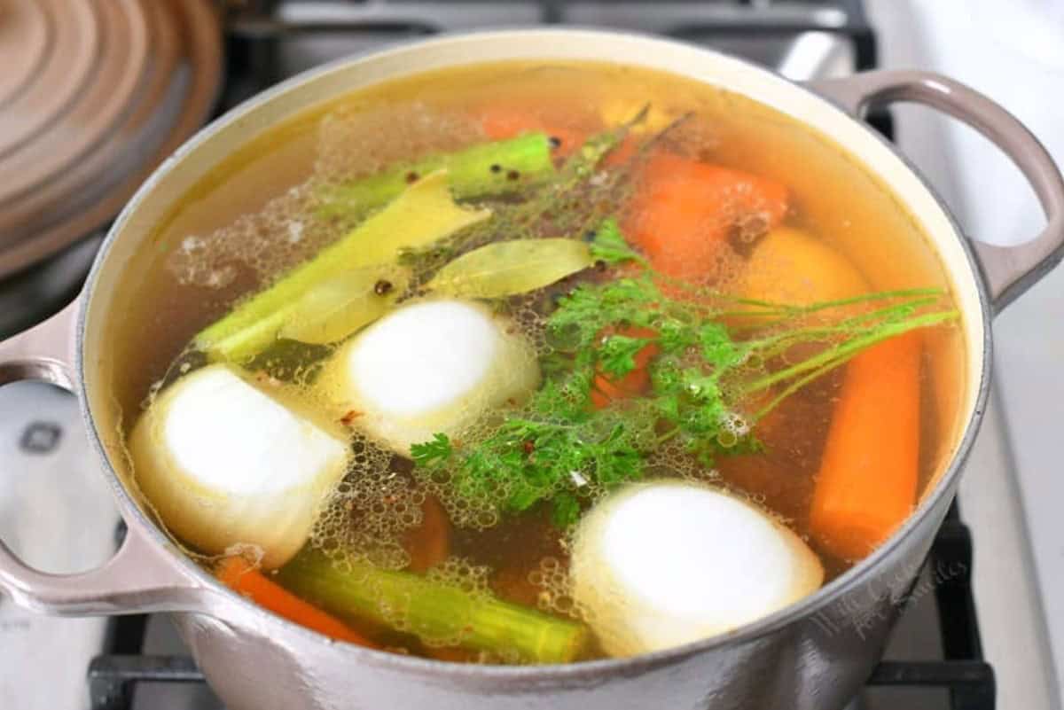 ingredients for beef stock in the pot on the stove before cooking.