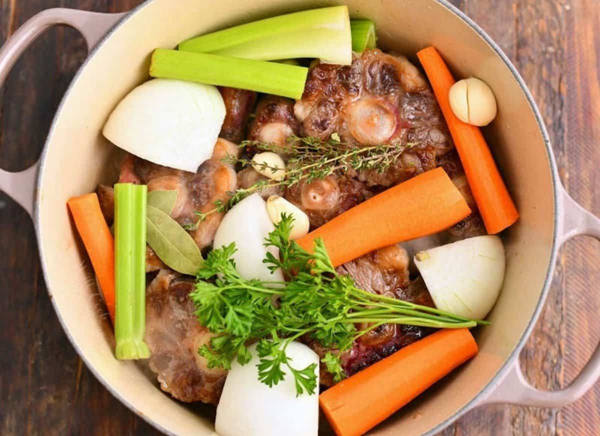 ingredients to make beef stock in a large Dutch oven pot.