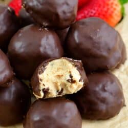 chocolate covered peanut butter cheesecake bites with one bite taken out.