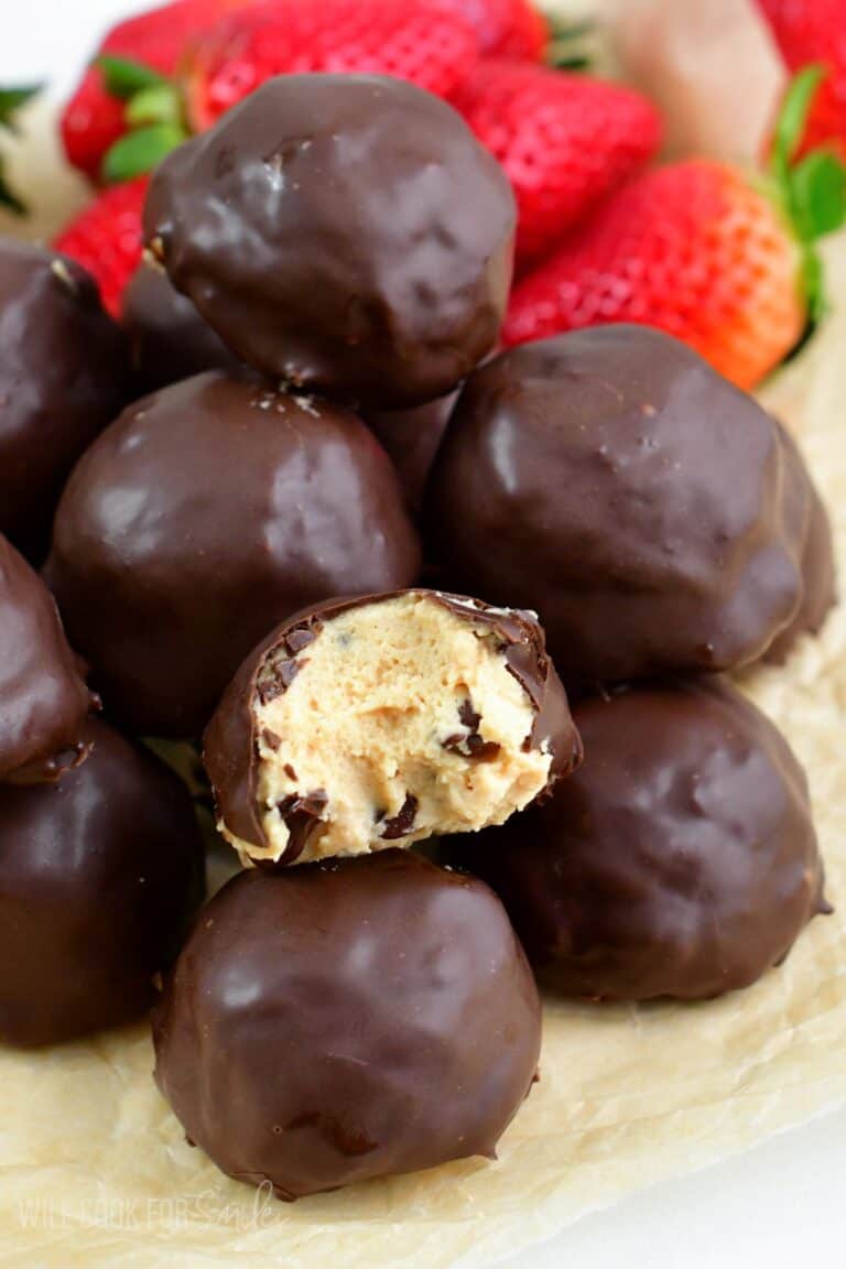 chocolate covered peanut butter cheesecake bites with one bite taken out.