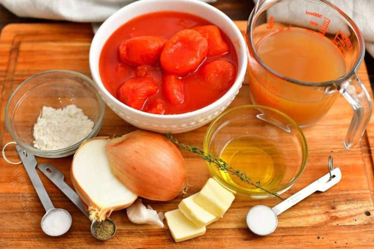 ingredients to make the classic tomato soup on the cutting board.