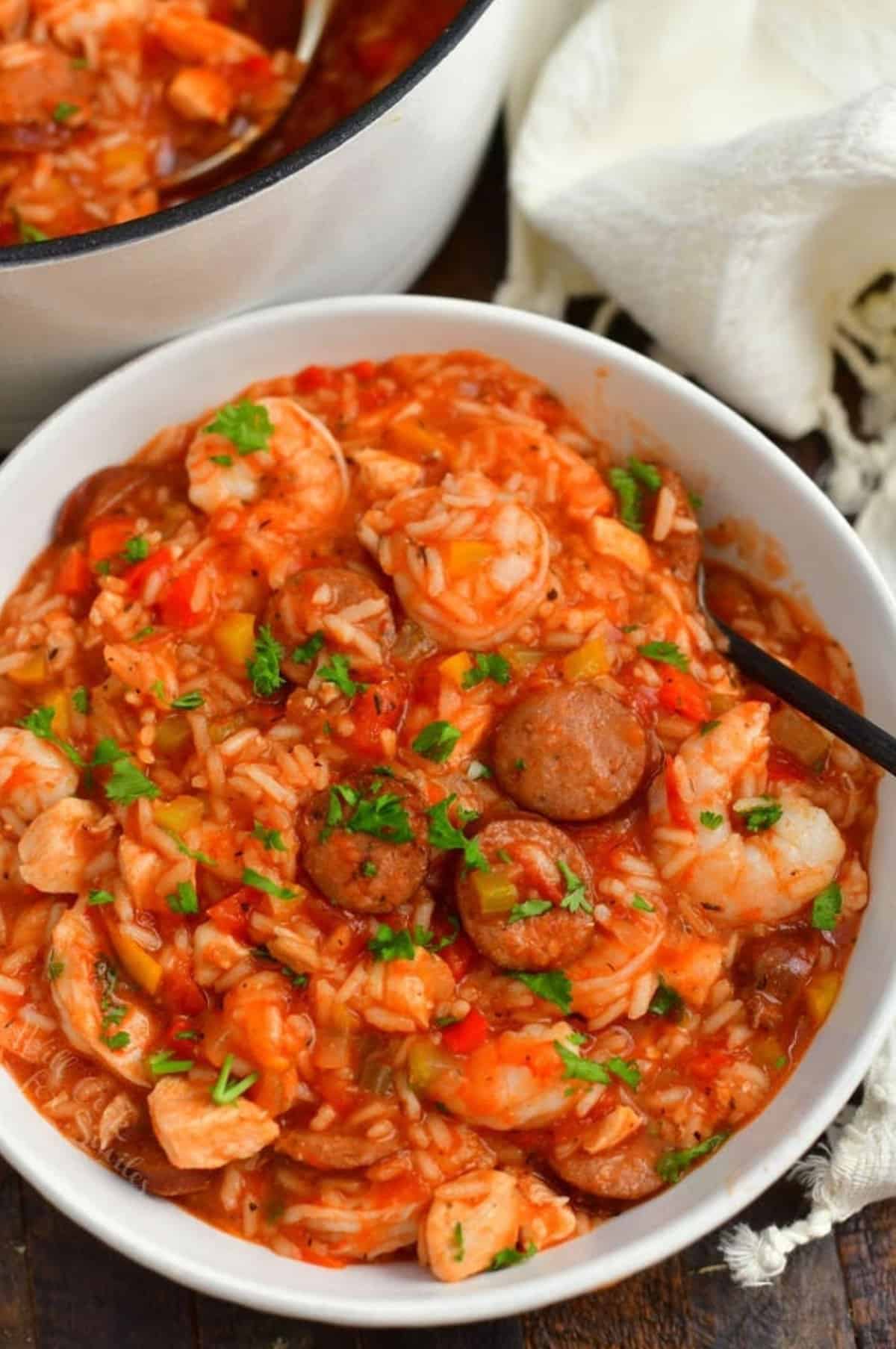 jambalaya in a white bowl with shrimp, sausage, and chicken visible.