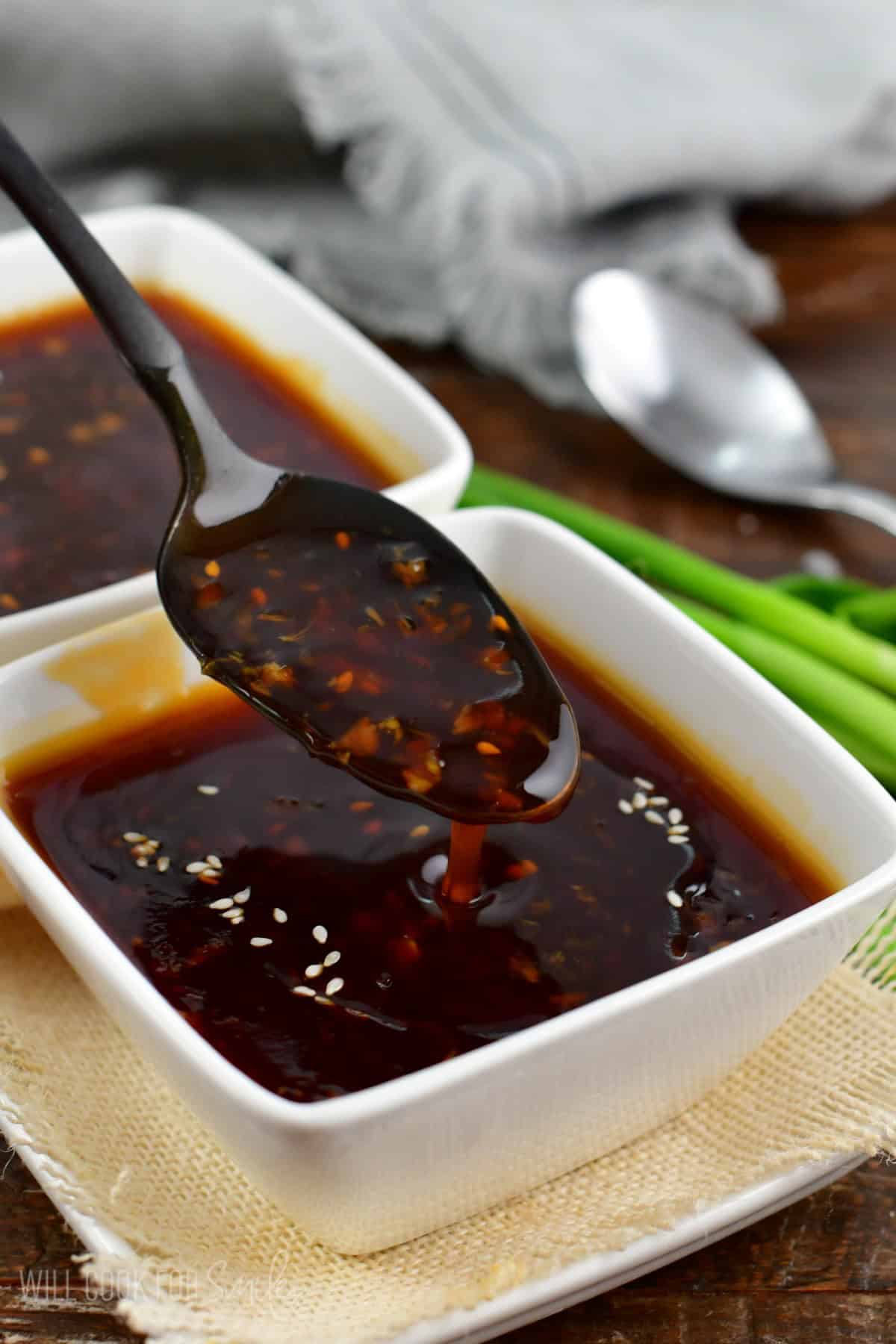 spooning out some teriyaki sauce and dripping off the spoon.