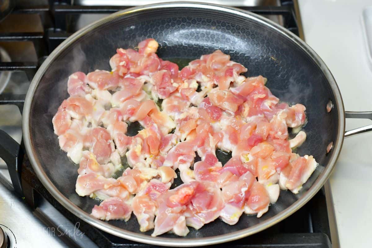 diced chicken thigh meat cooking in the pan.