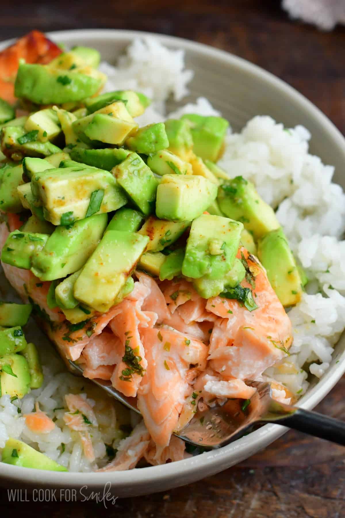 flaking some salmon with a fork and scooping it.