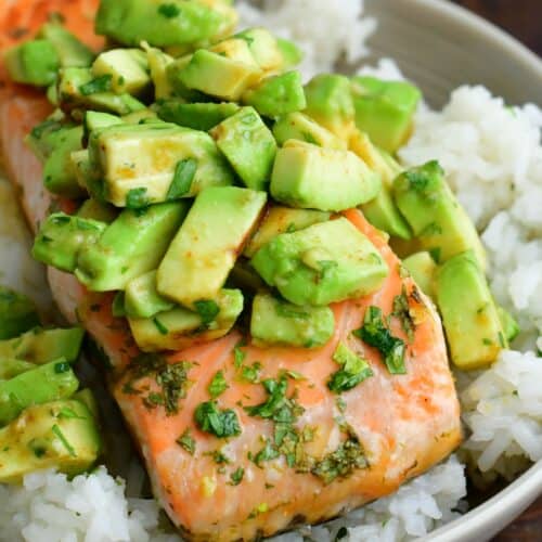 baked salmon over the bowl of rice topped with avocado topping.