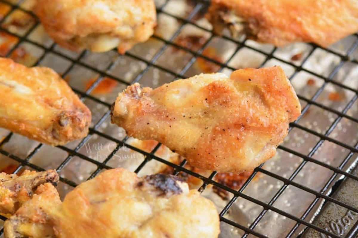 Baked chicken wings on a baking wire rack on top of a baking sheet.