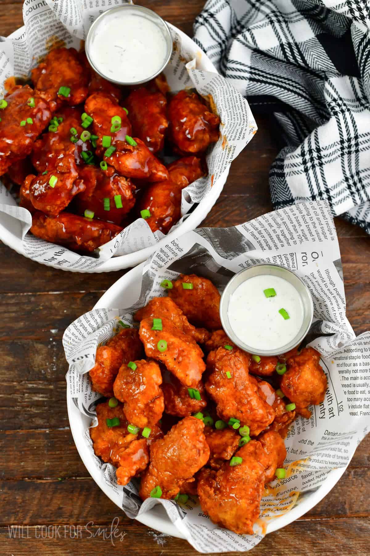 two bowls of boneless wings one with buffalo wing sauce and one with bbq.